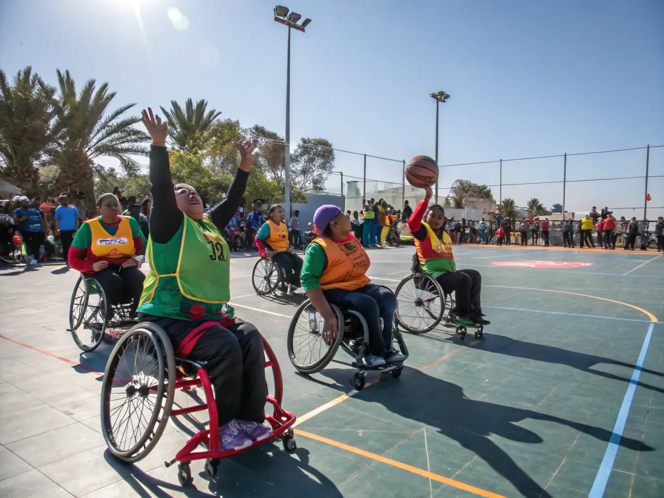 A group of children and adults with varying abilities participating in a modified basketball game, showcasing inclusivity and teamwork.